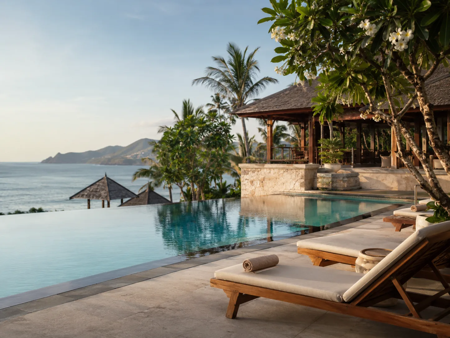 Infinity pool at a boutique tropical resort overlooking the ocean at sunset